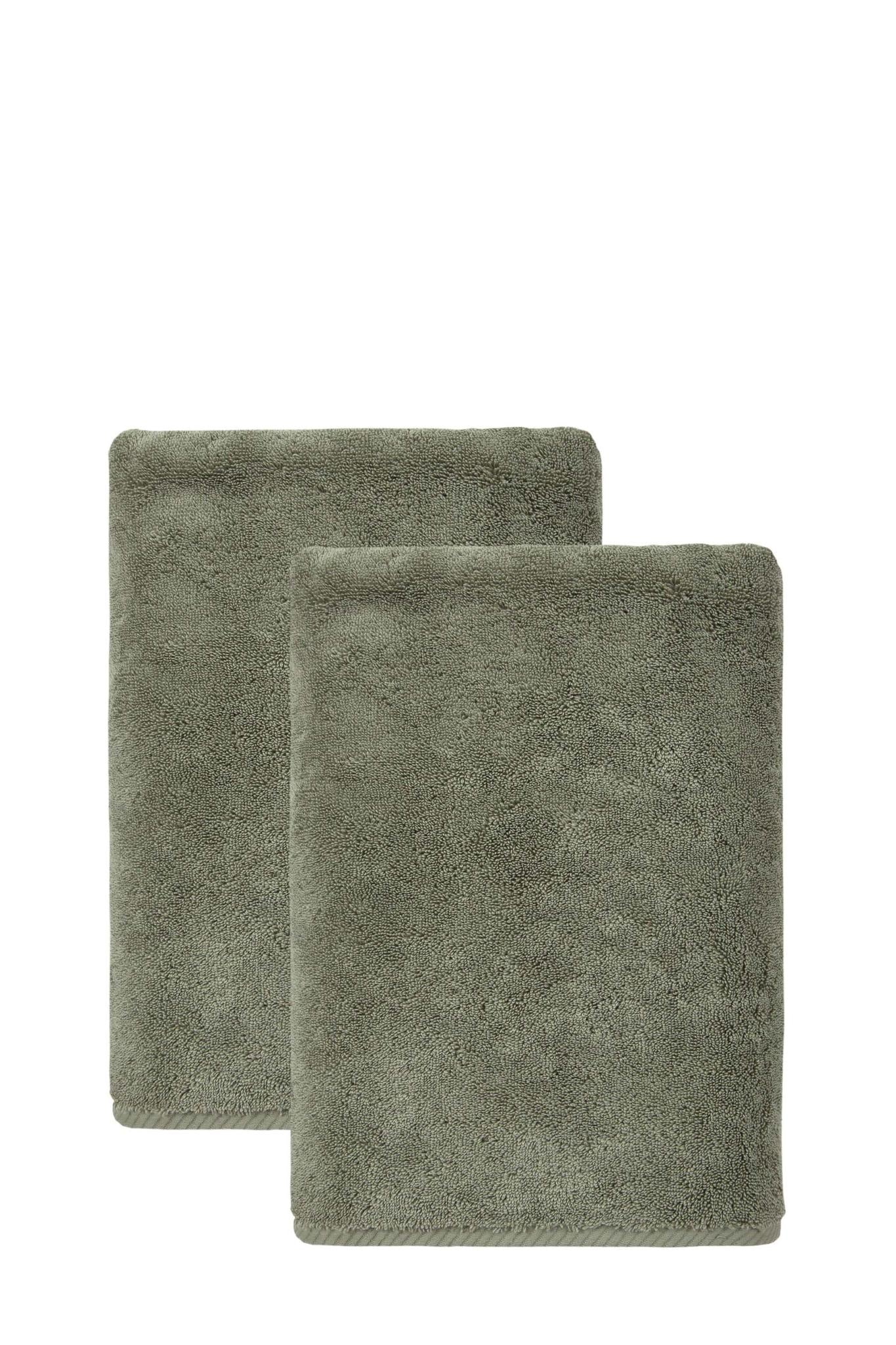 Set of two green Turkish cotton bath towels, folded and stacked