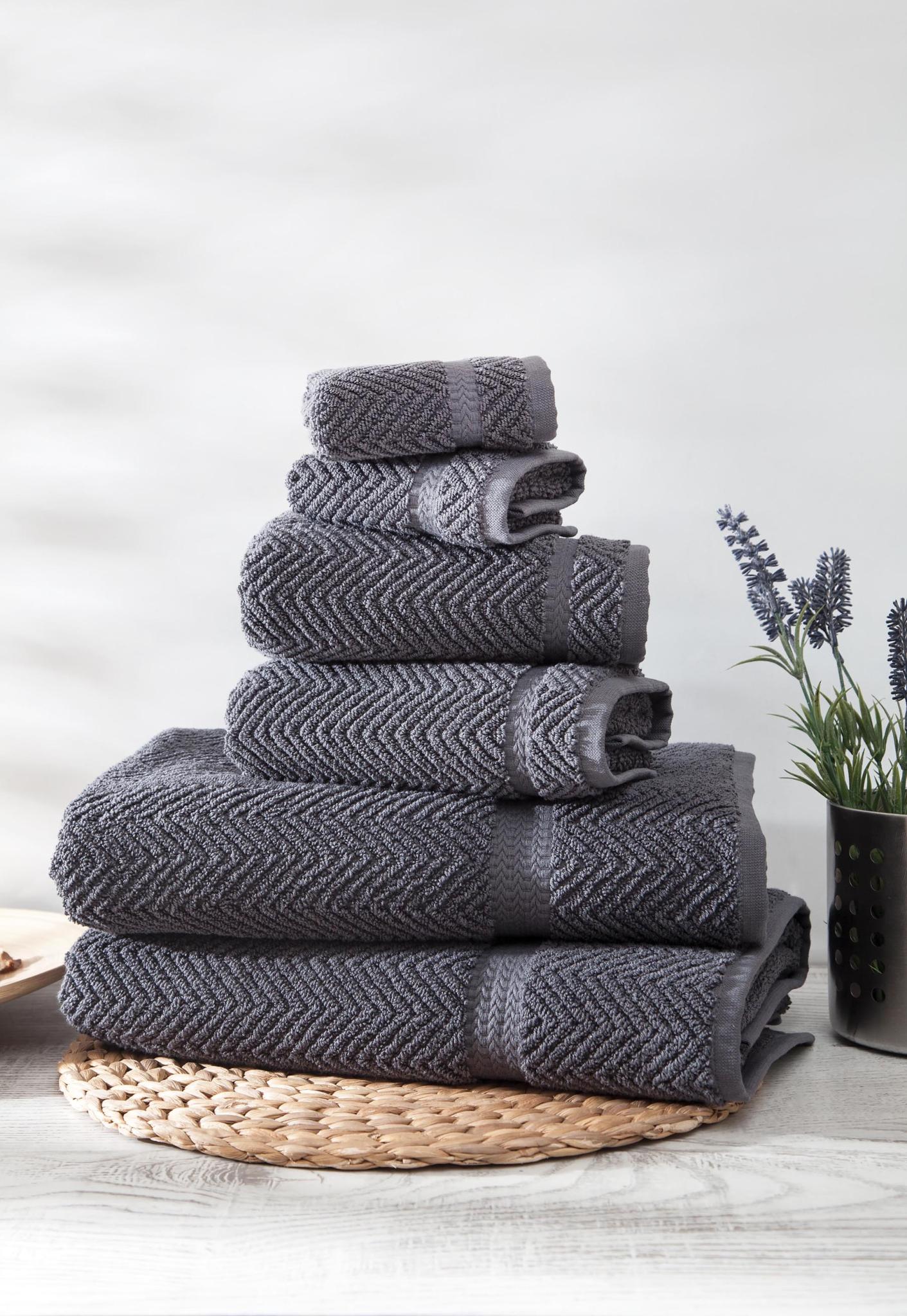 Set of six dark gray chevron Turkish cotton towels, neatly folded and stacked
