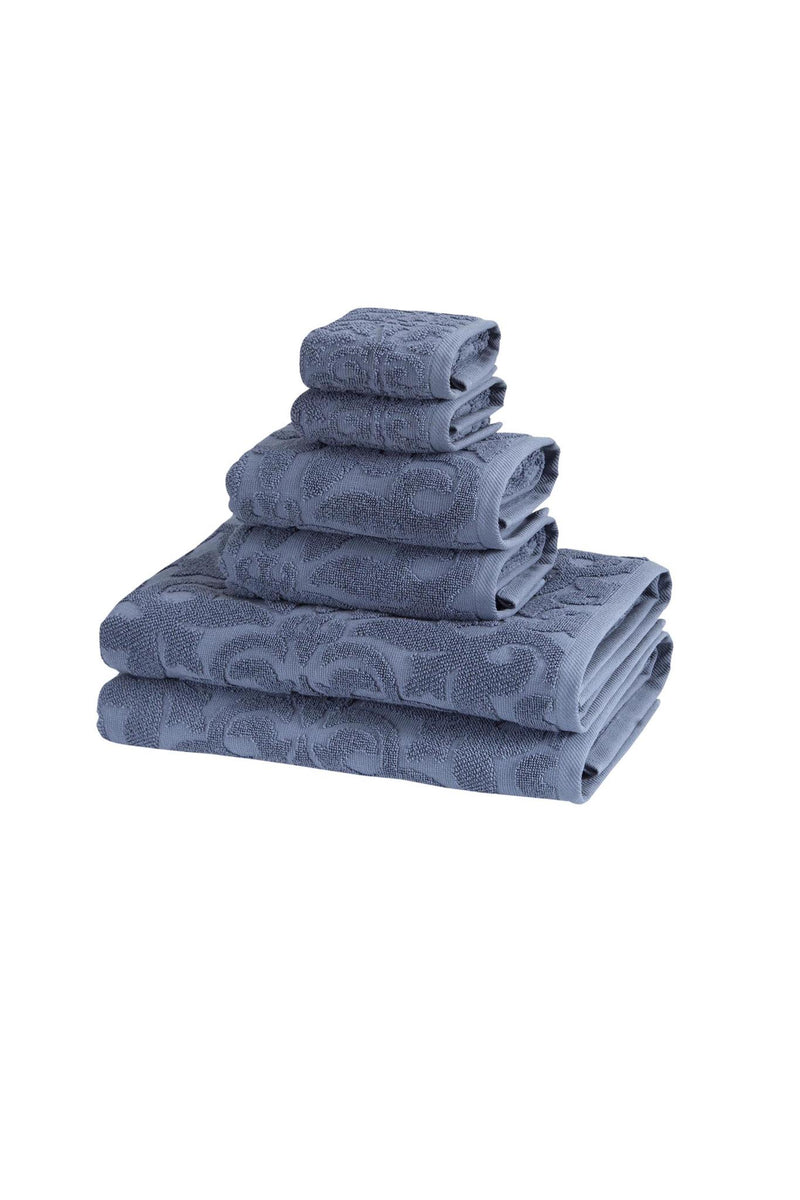 Stacked blue Turkish cotton towels with floral jacquard pattern, neatly folded