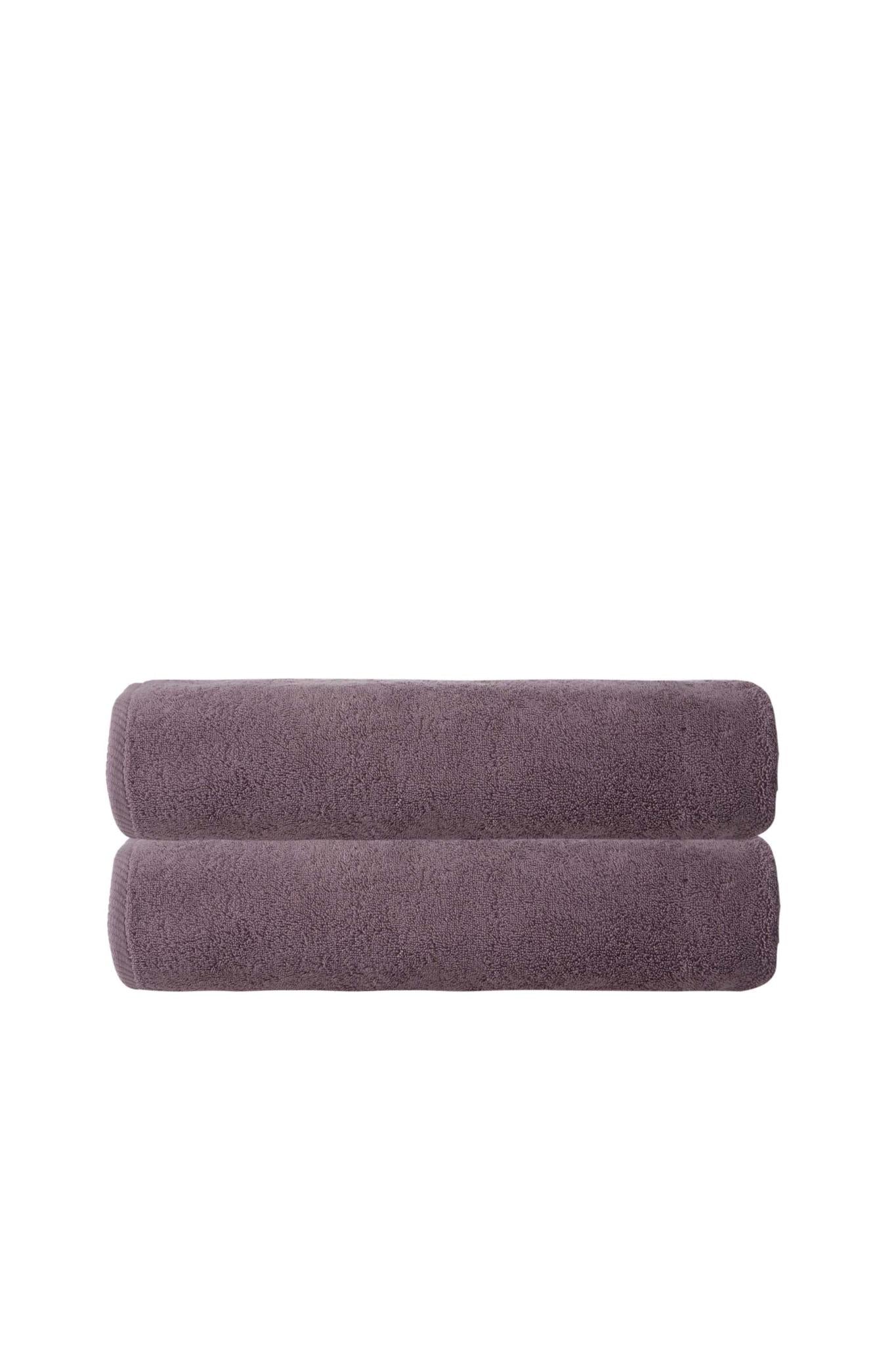 Set of two purple bath towels, rolled and stacked