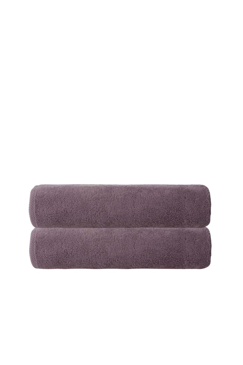 Set of two purple bath towels, rolled and stacked