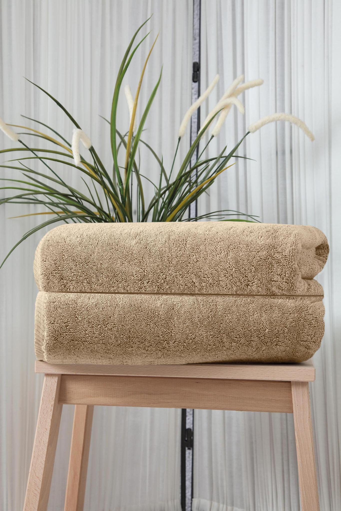 Set of two beige Turkish cotton bath towels, stacked and folded, textured loop pile