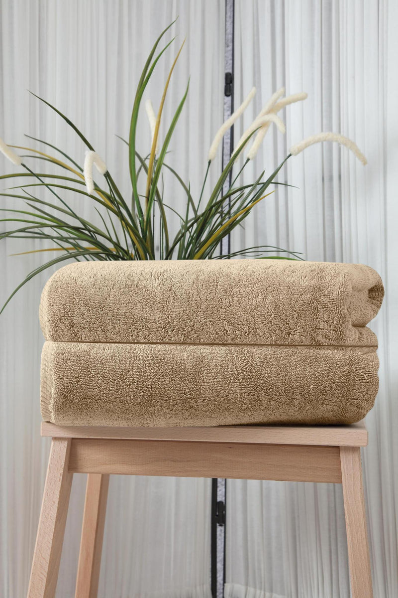Set of two beige Turkish cotton bath towels, stacked and folded, textured loop pile