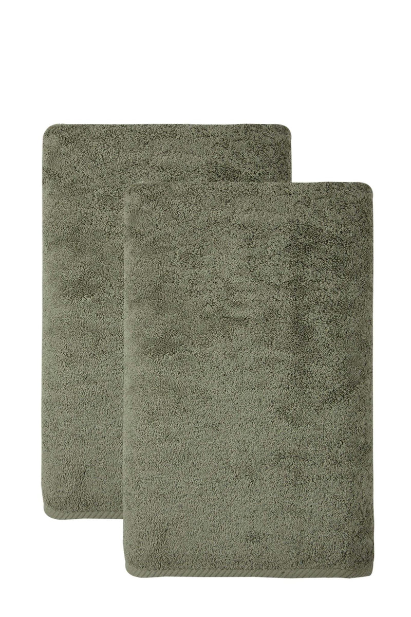 Set of two green Turkish cotton bath sheets, one folded upright behind the other