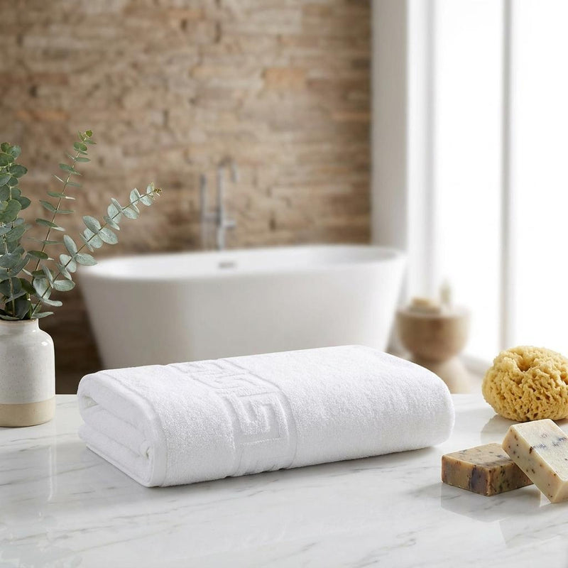 Two white bath sheets rolled and stacked, Greek key border visible at center