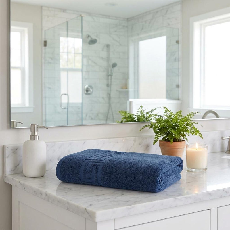 Navy bath sheet with Greek key woven border, neatly folded