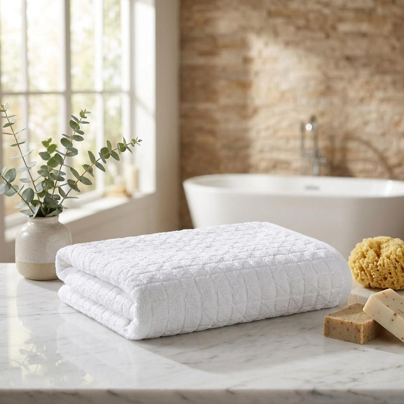 Folded white Turkish cotton towel with geometric weave on a countertop