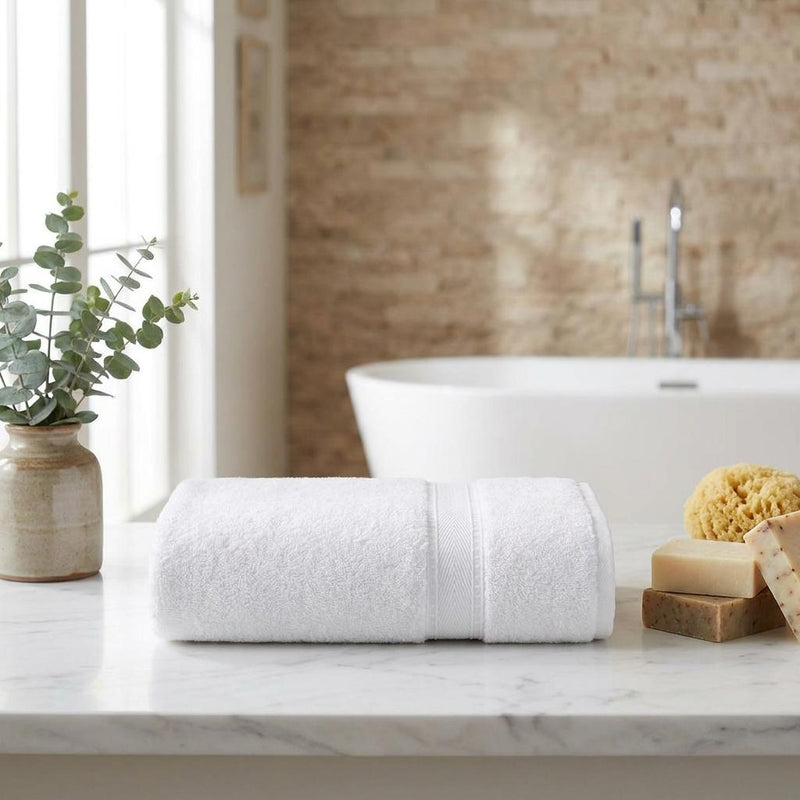 Set of two white Turkish cotton bath towels, rolled and secured with matching fabric bands