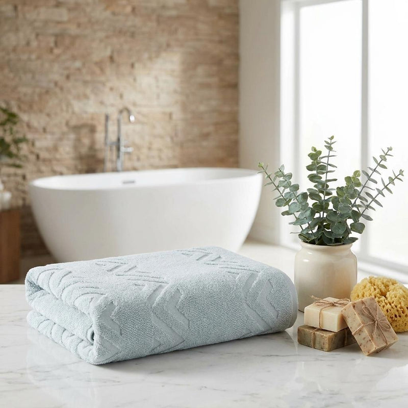 Folded aqua towel with chevron geometric pattern on bathroom counter