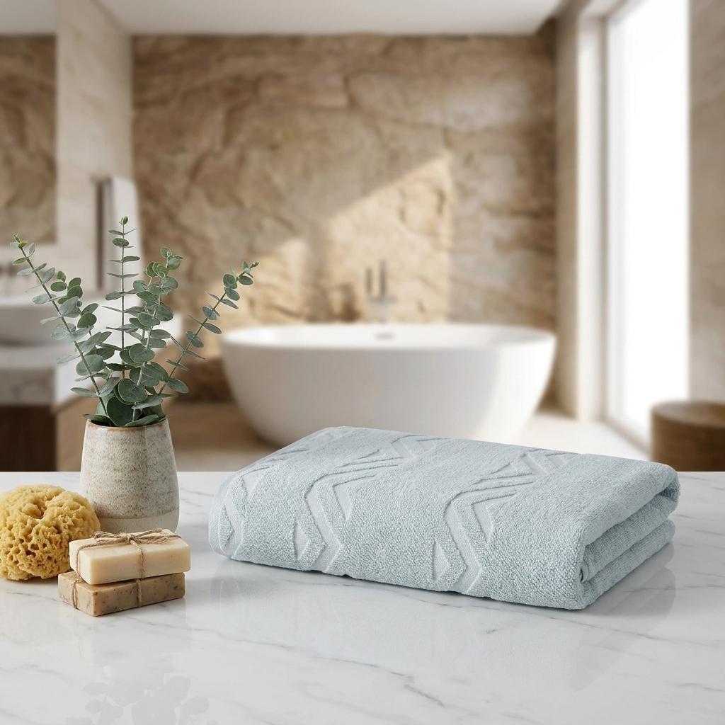 Aqua bath sheet stack on countertop with embossed chevron geometric pattern