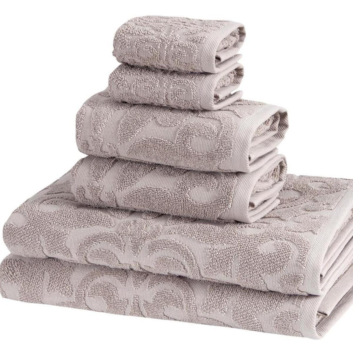 Light gray floral Turkish cotton towel set, six folded towels with textured pattern.