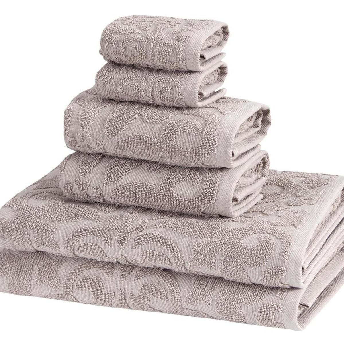 Light gray floral Turkish cotton towels with raised pattern, folded in a compact stack.