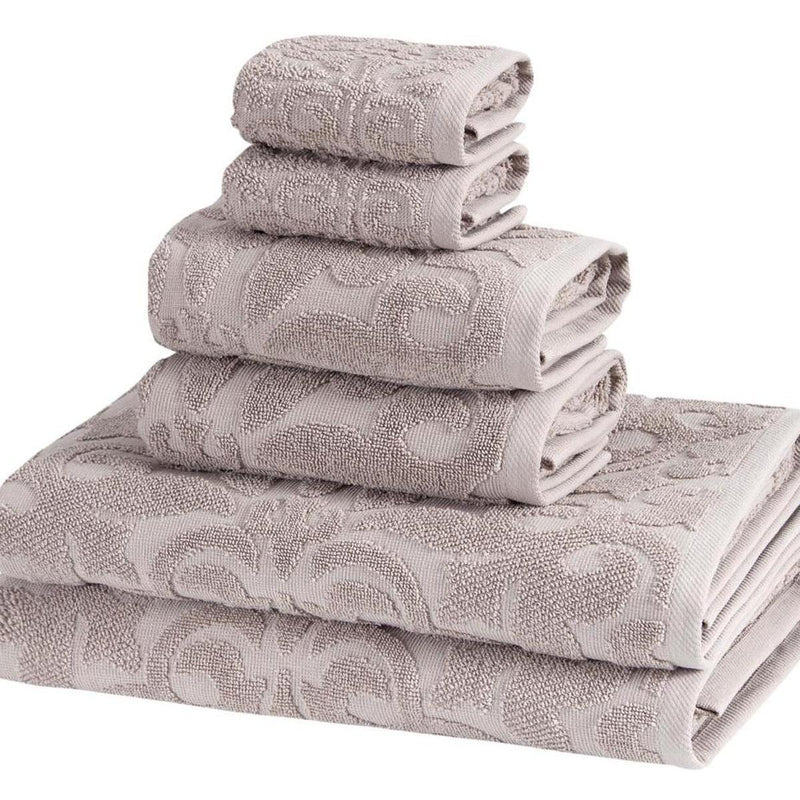 Light gray floral Turkish cotton towels with raised pattern, folded in a compact stack.