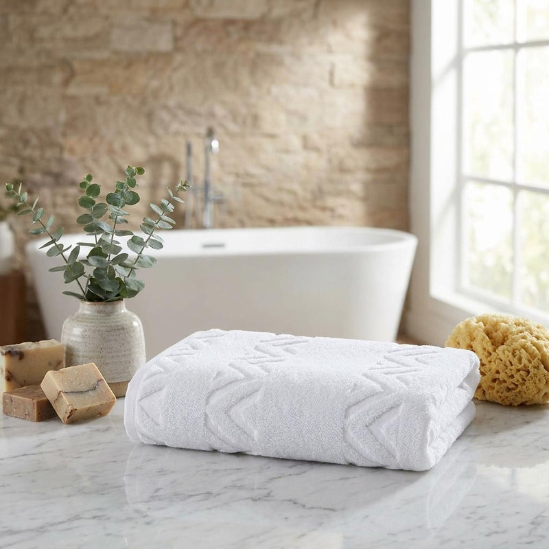 Set of six Turkish cotton towels, white chevron towel folded on bathroom counter