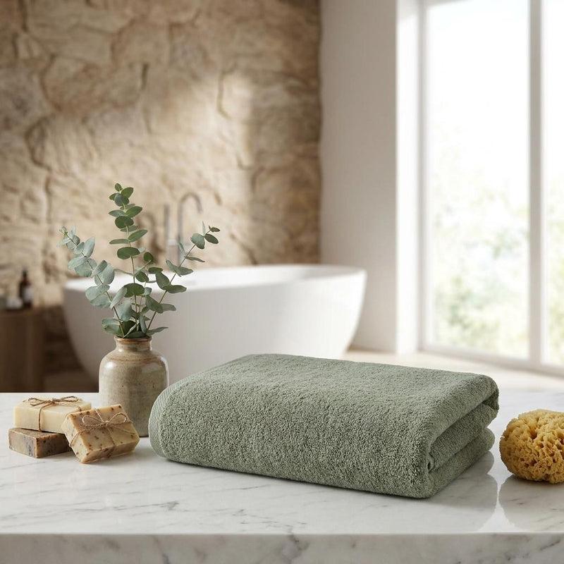 Green Turkish cotton bath sheet set, neatly folded on a countertop