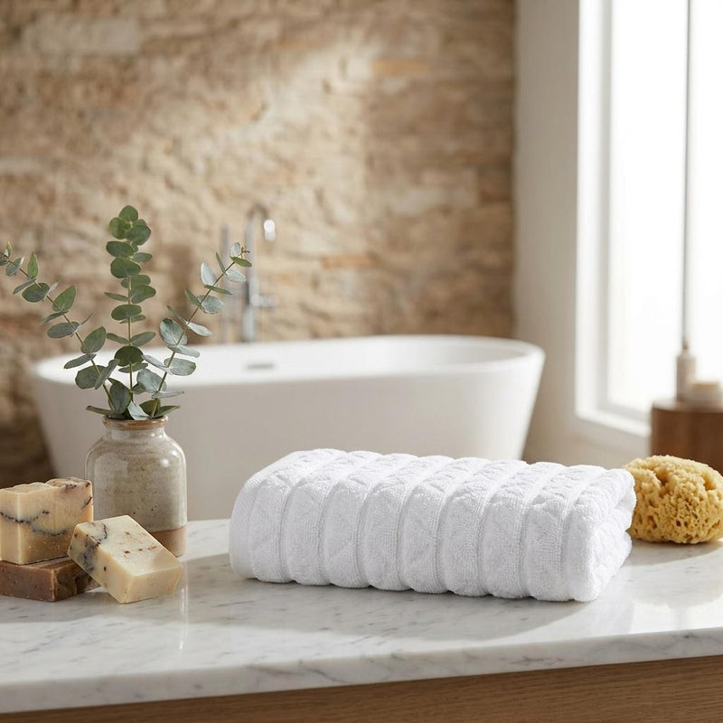 White Turkish hand towel set with textured geometric pattern, folded on a surface