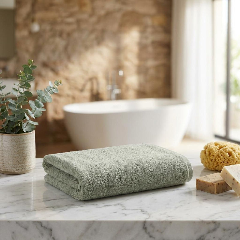 Set of two green Turkish cotton hand towels, folded on counter, terry texture