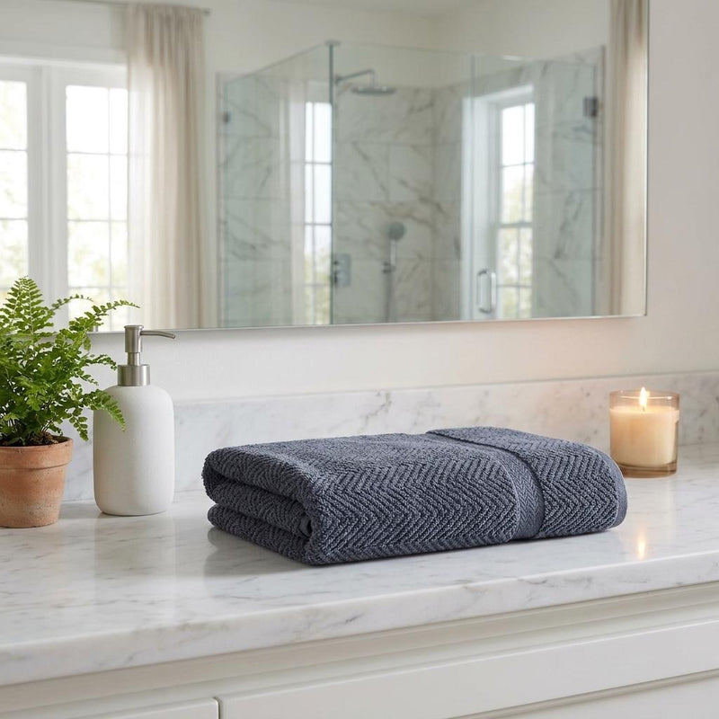 Light gray chevron bath towel set folded on bathroom countertop