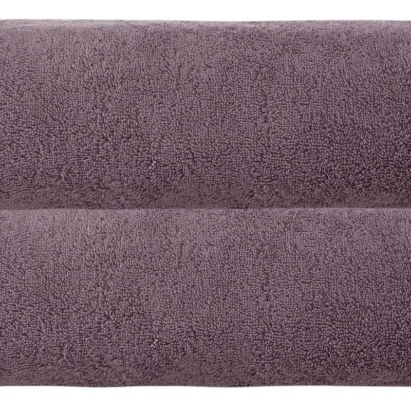 Close-up of purple terry bath sheet fabric with dense looped texture.