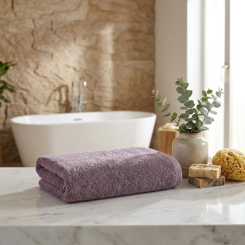 Purple hand towel folded on a countertop, terry loop texture