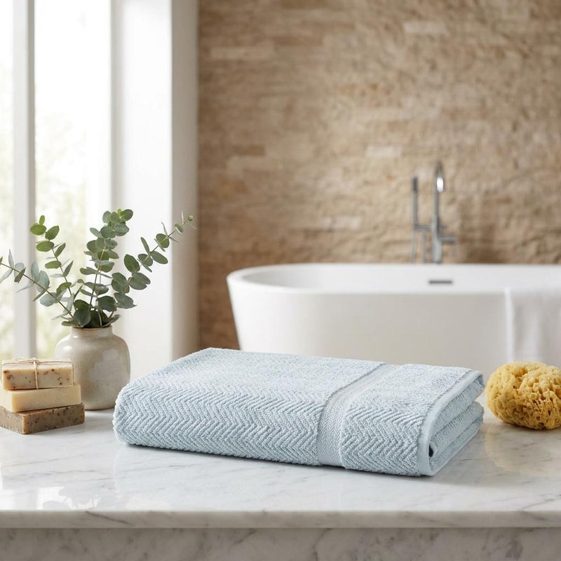 Light blue chevron Turkish cotton bath sheet set, neatly folded on countertop