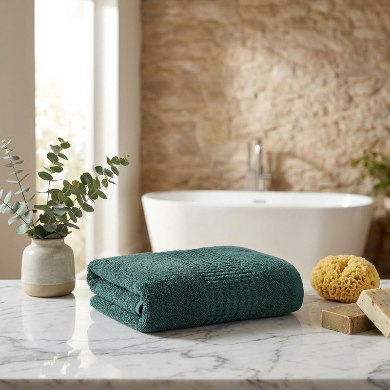 Green Turkish cotton hand towel, neatly folded on a countertop