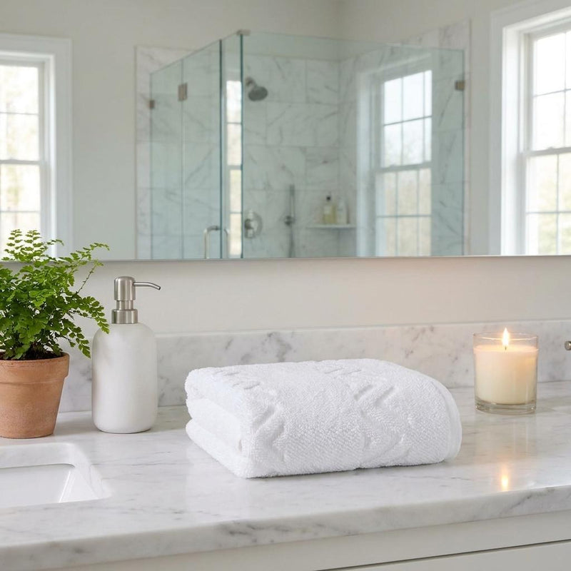 White geometric Turkish hand towel rolled on bathroom countertop