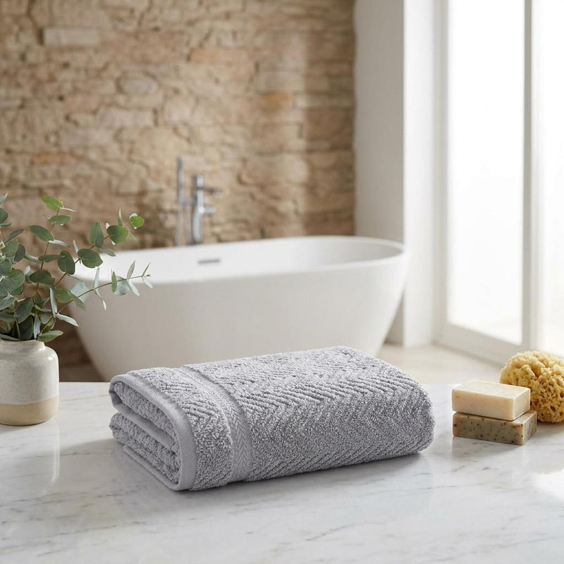Set of two light gray chevron hand towels, neatly rolled with stitched edge