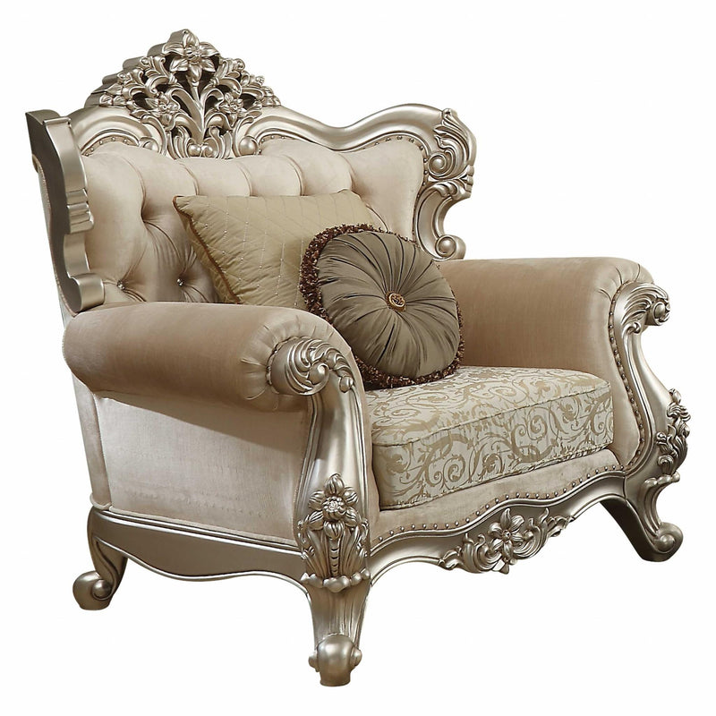 Champagne fabric armchair with damask seat, carved silver back, and round toss pillow