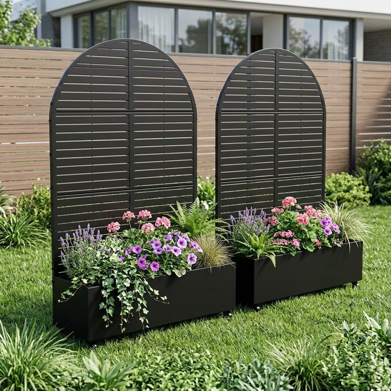 Set of two black oval metal planter boxes with horizontal slats, filled with flowers