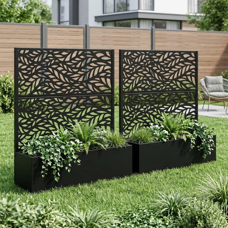 Two black rectangular metal planter boxes with botanical leaf panels and green plants
