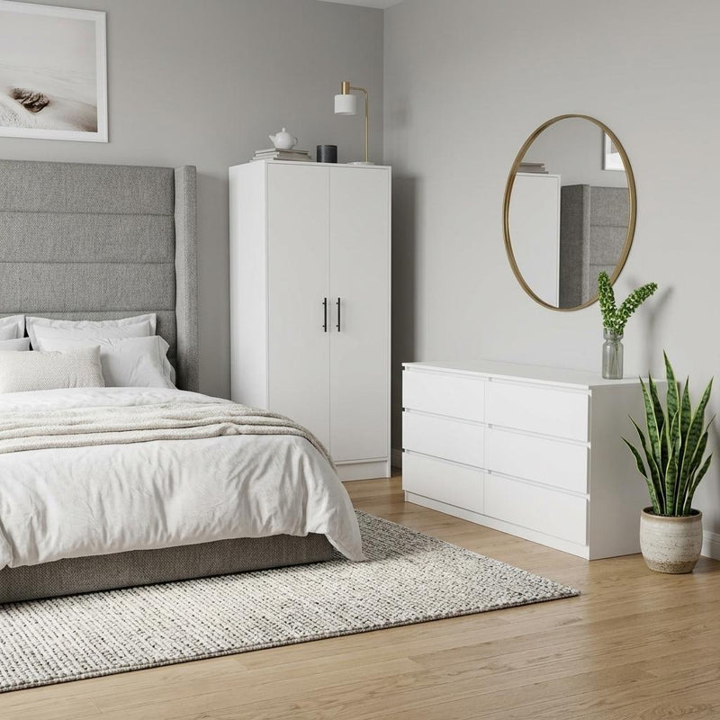 White bedroom furniture set with wardrobe, low dresser, and round wall mirror