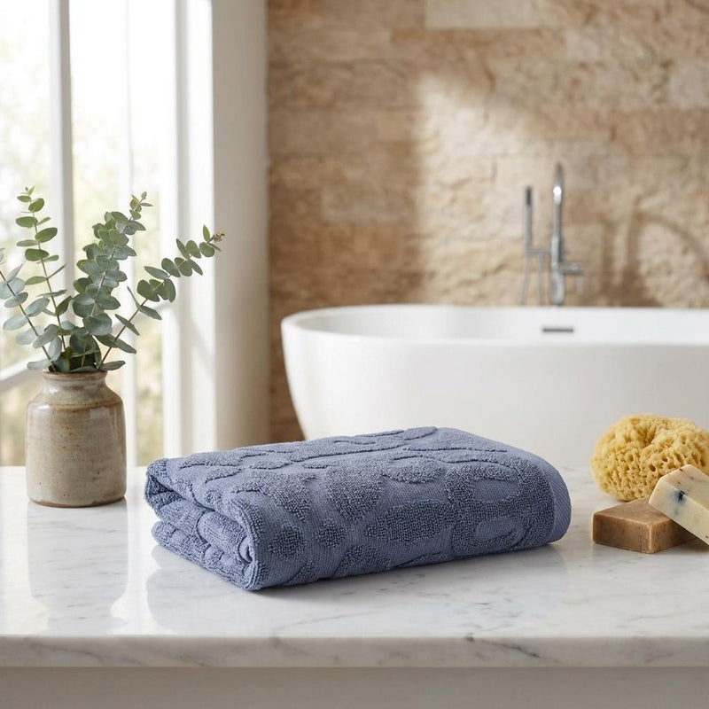 Navy blue floral Turkish cotton hand towel set, rolled and stacked on counter