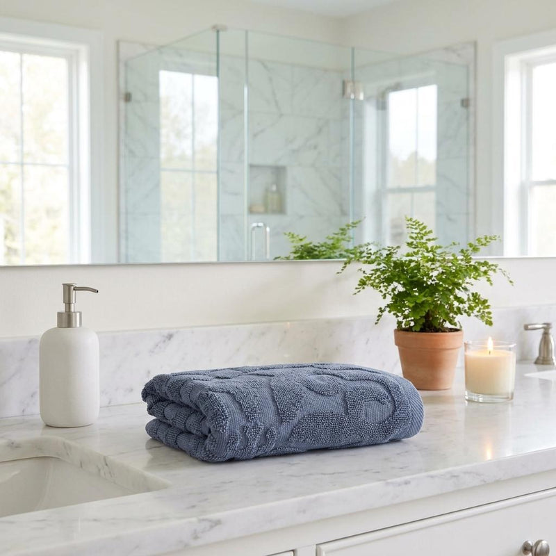Blue Turkish cotton hand towel with tonal floral pattern, neatly folded, 16x30 in