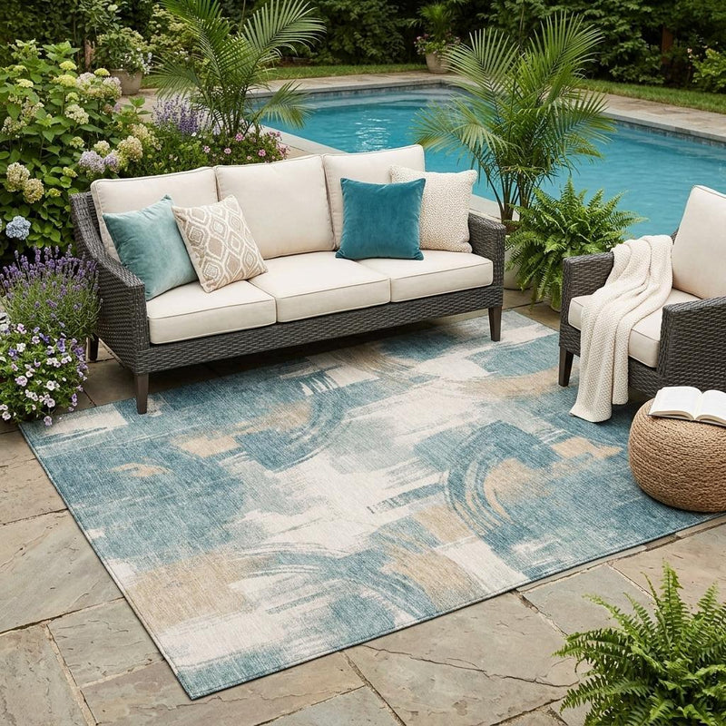 Indoor outdoor area rug with teal-and-cream abstract wash pattern