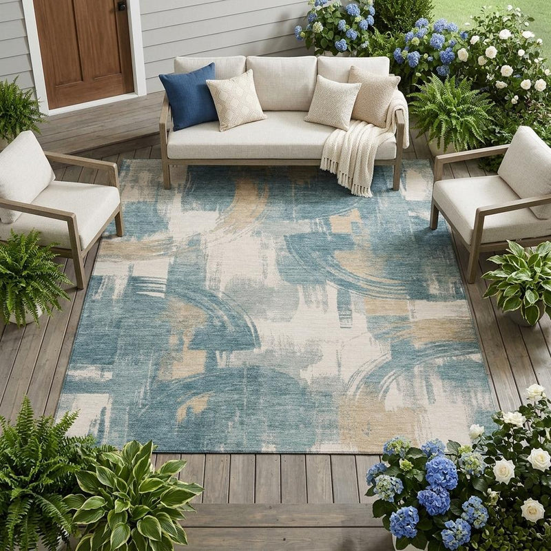 Indoor/outdoor area rug with abstract teal and beige brush design on light ground