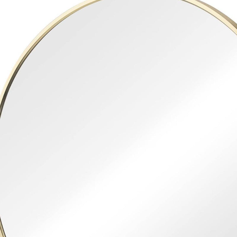 Close-up of gold metal rim on round bathroom mirror