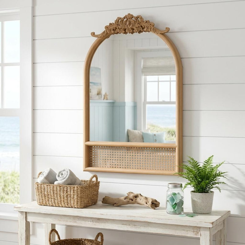 Brown arched accent mirror with scrollwork top and perforated rattan panel at bottom