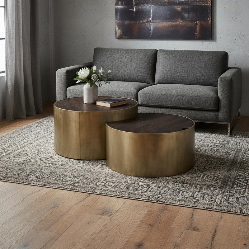 Set of two round nesting coffee tables with dark wood tops on gold metal bases