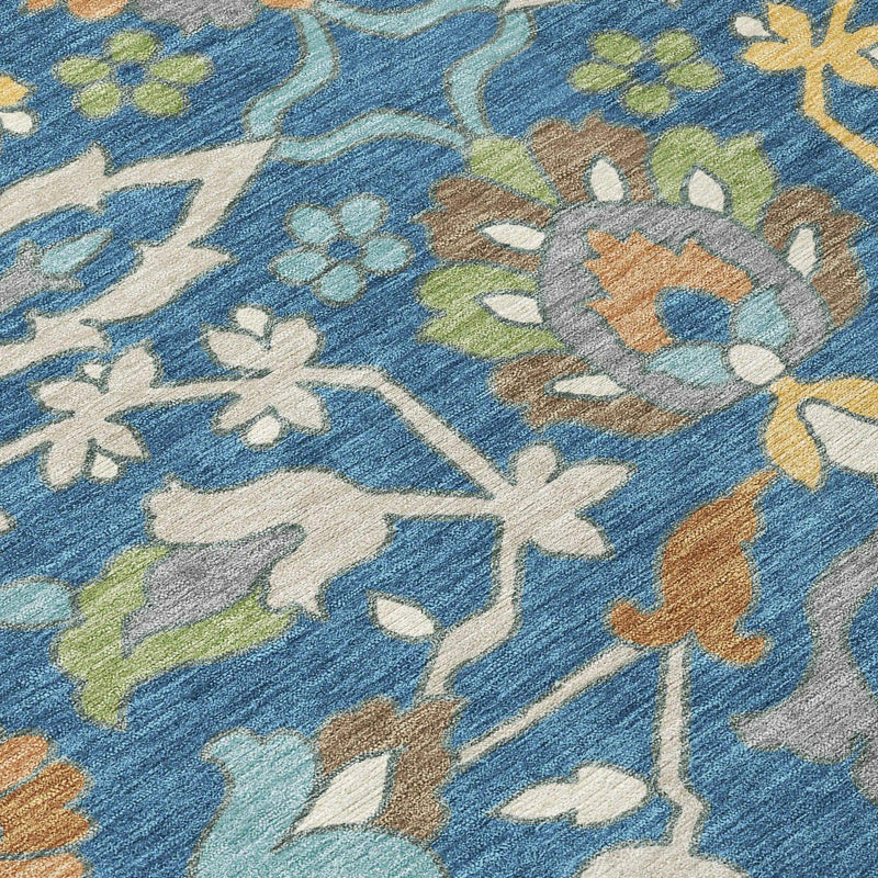 Blue floral area rug with colorful patterns in orange, green, and brown, perfect for modern and bohemian decor.