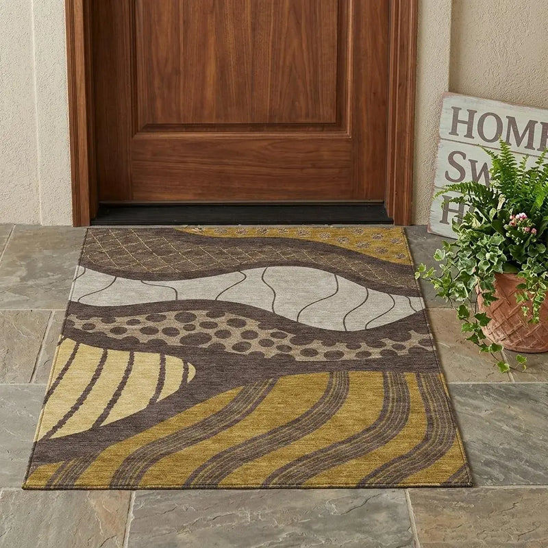 Multicolored abstract area rug in shades of yellow, gray, and brown; durable indoor/outdoor fabric, modern style.