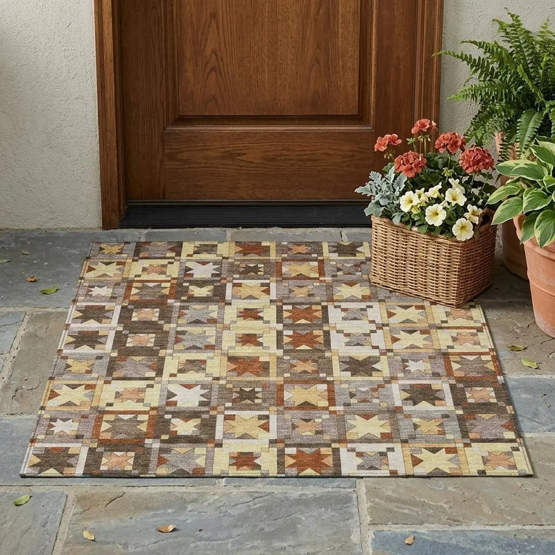 Colorful patterned outdoor rug in earthy tones of brown, yellow, and gray, perfect for entryways and porches.
