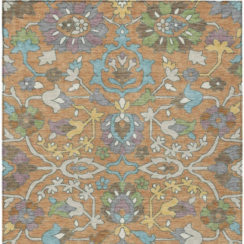 Vintage-style area rug in warm orange with floral patterns in blue, green, and yellow hues, perfect for any home decor.