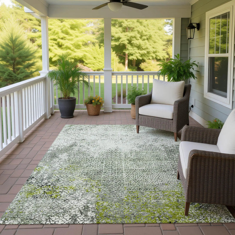 Light green and gray patterned outdoor rug on porch, with wicker chairs and potted plants, creating a cozy atmosphere.