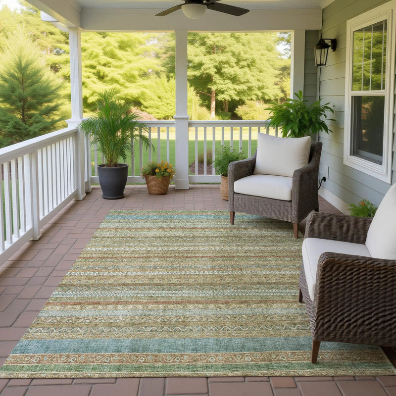 Light blue and beige striped outdoor area rug on a patio, featuring a decorative design, perfect for enhancing outdoor spaces.