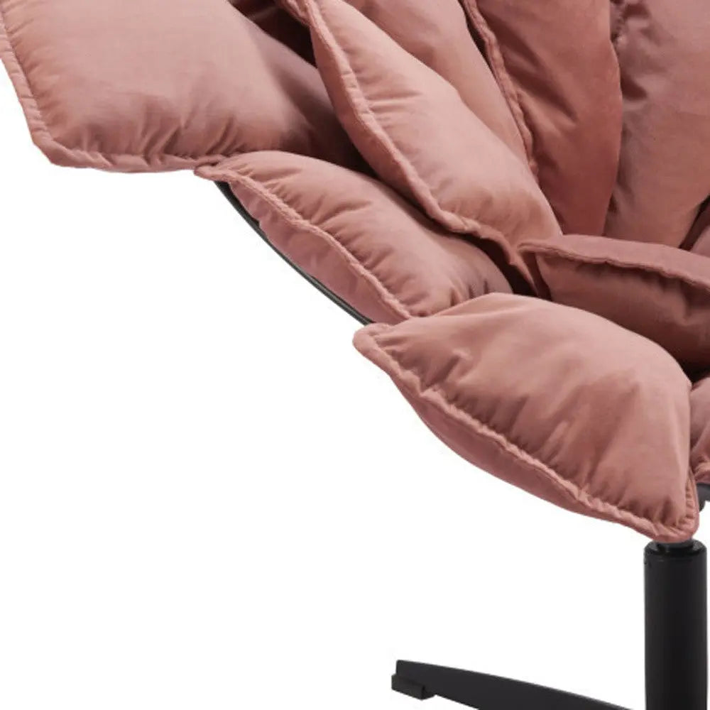 Dusty pink oversized lounge chair with plush velvet cushions and a sleek black metal base. Perfect for modern decor.