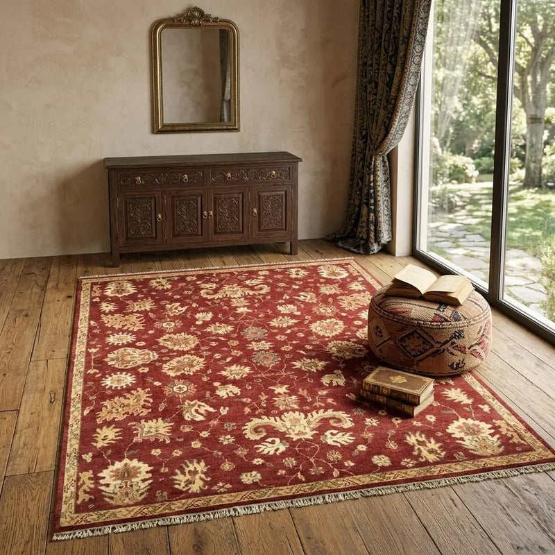 Red floral area rug with gold accents, perfect for cozy living spaces, on hardwood floor with wooden console and decor.