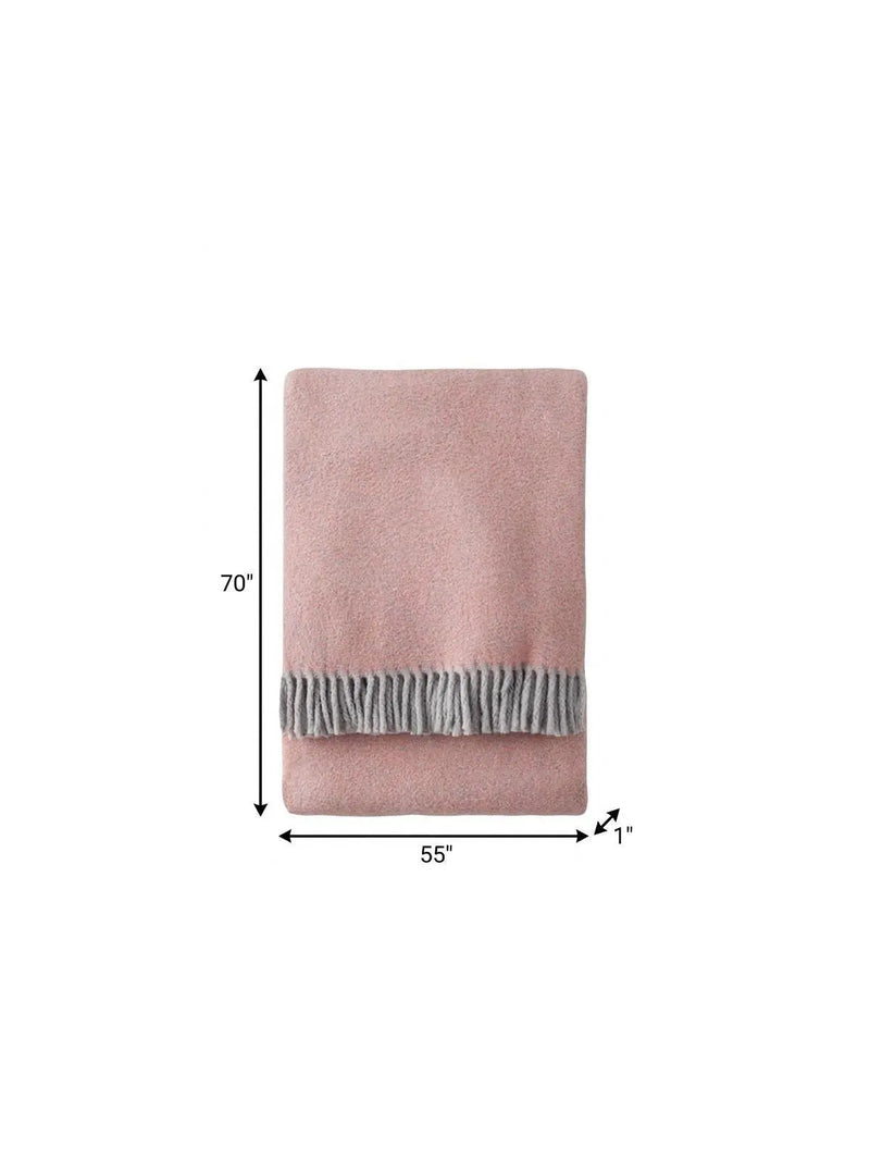 Cozy pink fleece throw blanket with gray fringed edge, 70"x55", perfect for warmth and style in any setting.