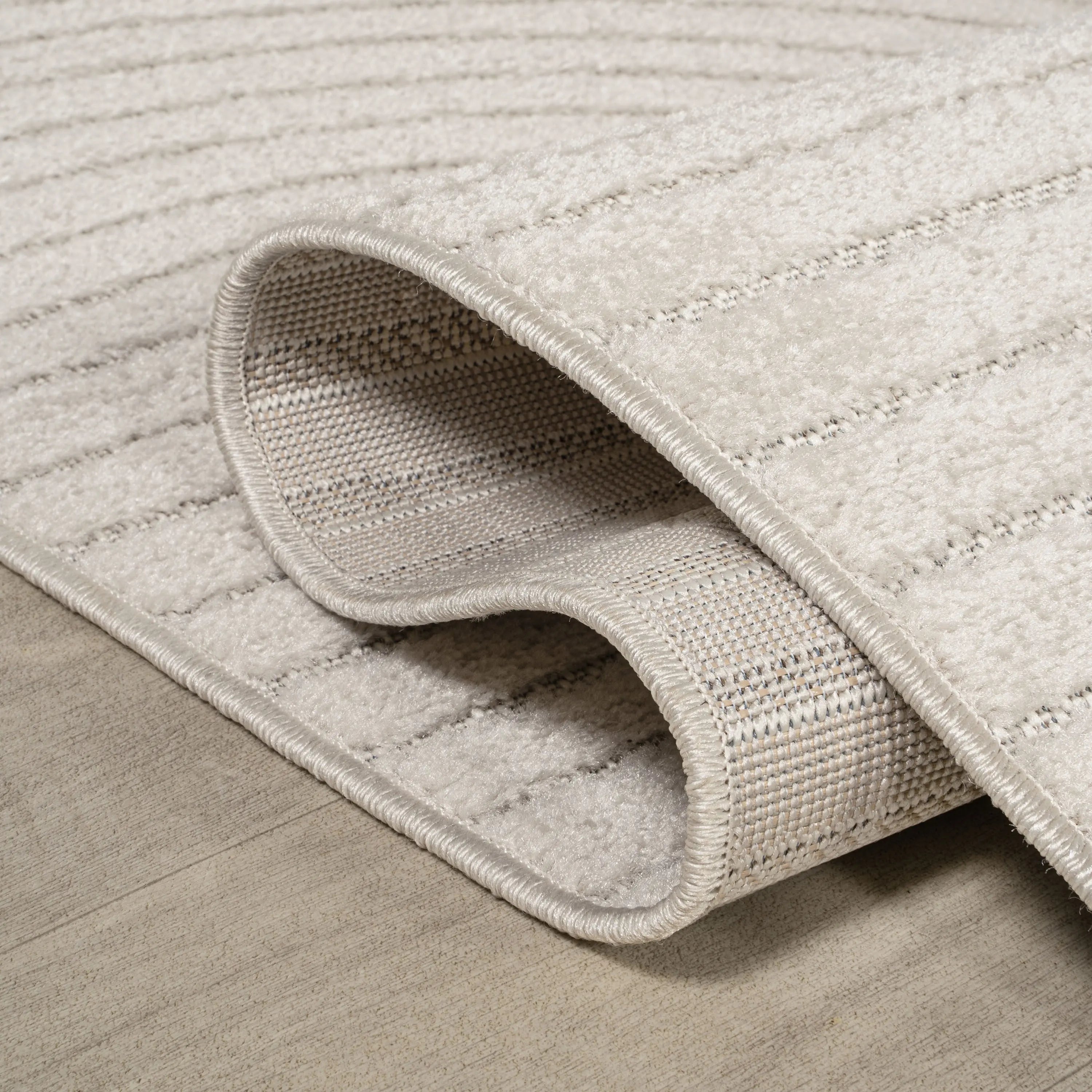 Cream textured area rug with striped pattern, featuring a soft pile and lasting durability, perfect for modern decor.