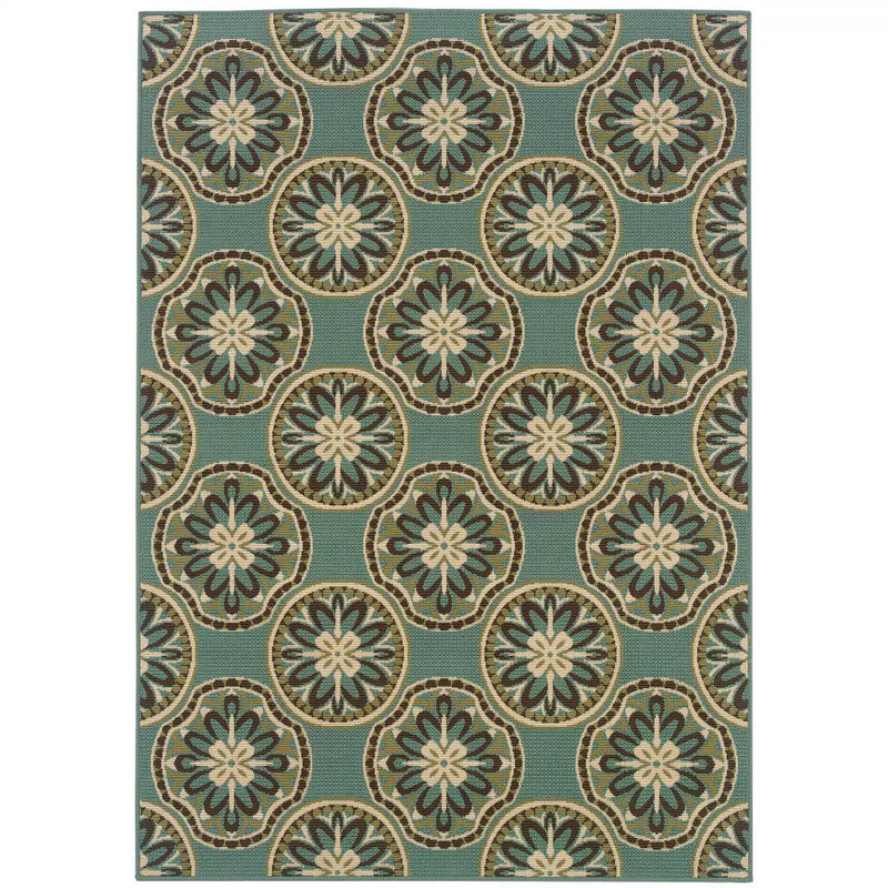 Blue geometric outdoor rug with floral medallion patterns in cream, brown, and green tones. Durable woven material.